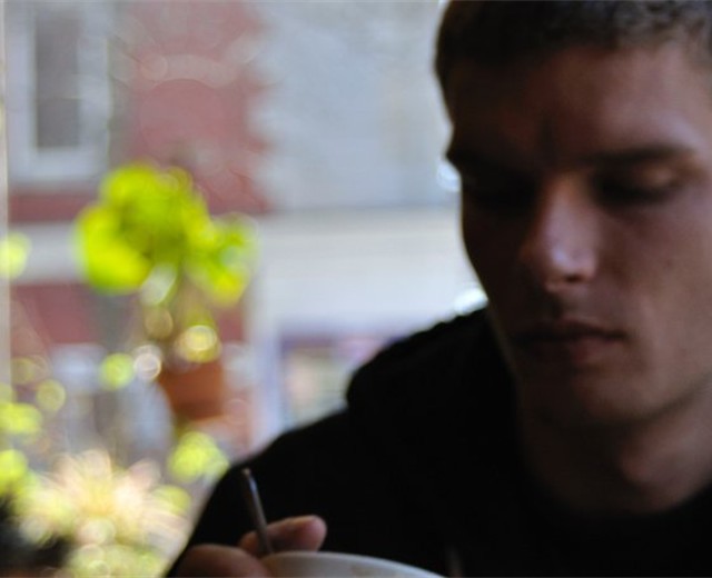 Donald Morton sitting indoors with a mug in hand.